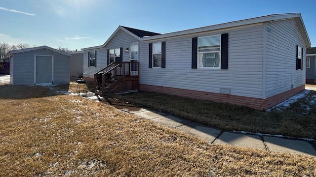 manufactured / mobile home with a storage unit and a front yard