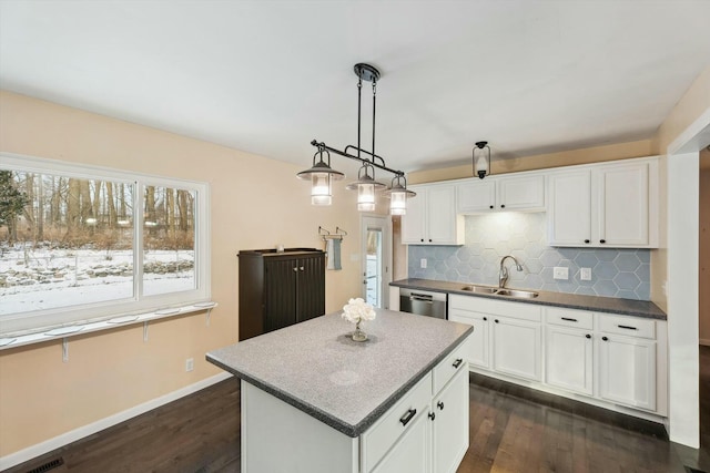 kitchen featuring hanging light fixtures, sink, stainless steel dishwasher, and white cabinets