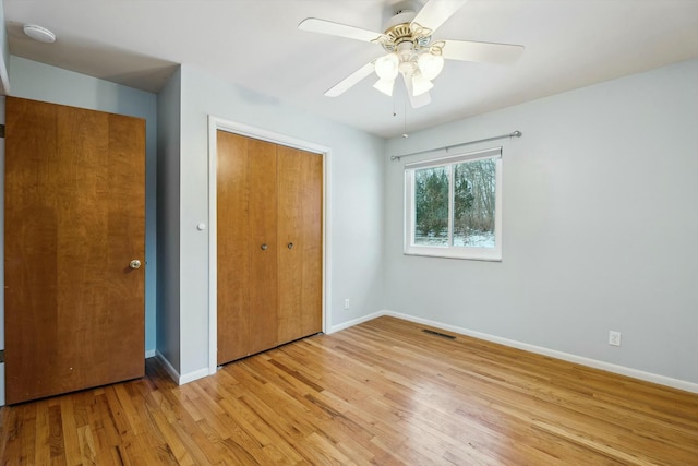 unfurnished bedroom with light hardwood / wood-style floors, ceiling fan, and a closet