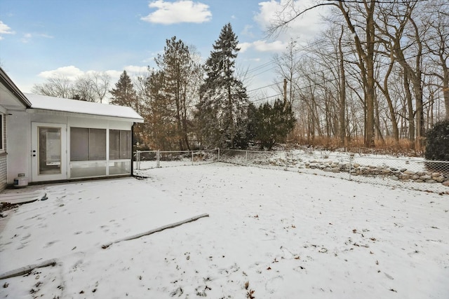 yard covered in snow with a sunroom