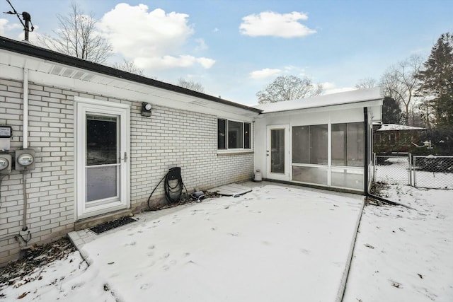 snow covered property with a sunroom