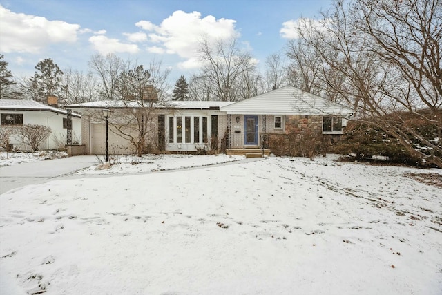 snow covered rear of property featuring a garage