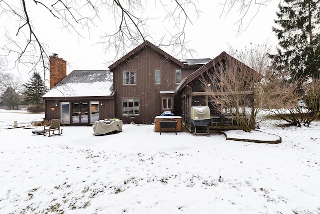 view of snow covered back of property