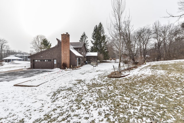 yard layered in snow featuring a garage