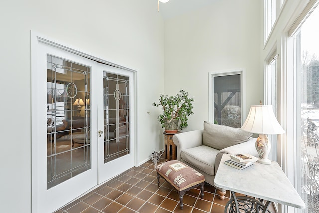 living area featuring dark tile patterned flooring and a high ceiling