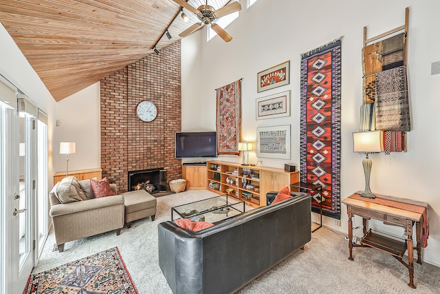 carpeted living room with wood ceiling, ceiling fan, a brick fireplace, and a wealth of natural light