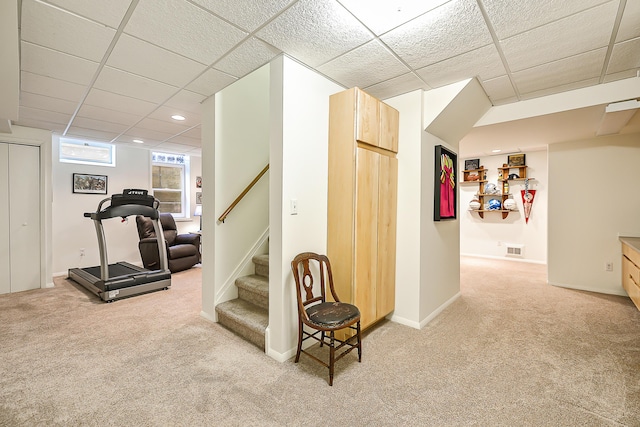 workout area featuring a paneled ceiling and carpet