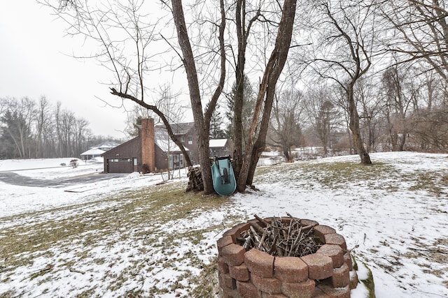 yard covered in snow with a fire pit