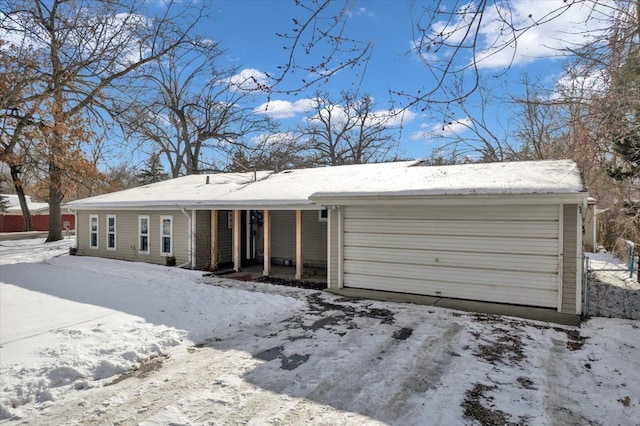 snow covered property with a garage