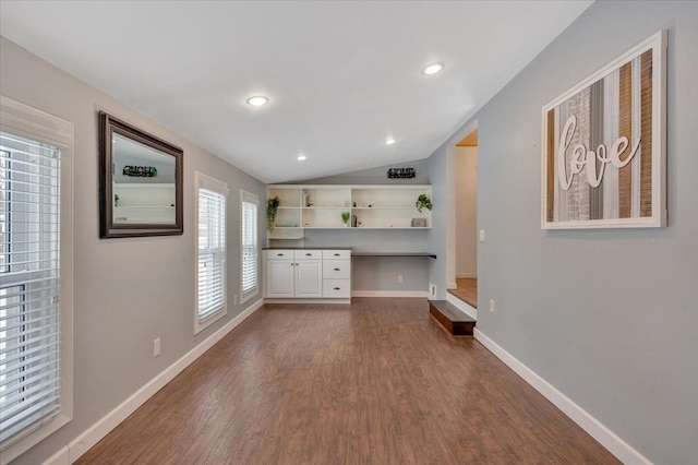 kitchen featuring dark wood-type flooring, white cabinets, and vaulted ceiling