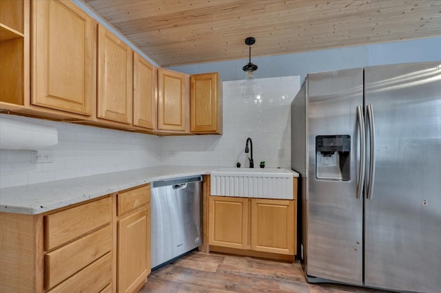 kitchen with pendant lighting, sink, stainless steel appliances, and light brown cabinets