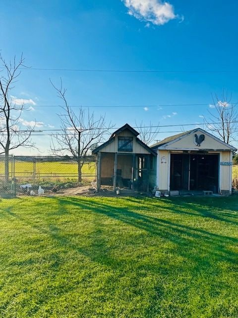 rear view of property featuring an outdoor structure and a lawn