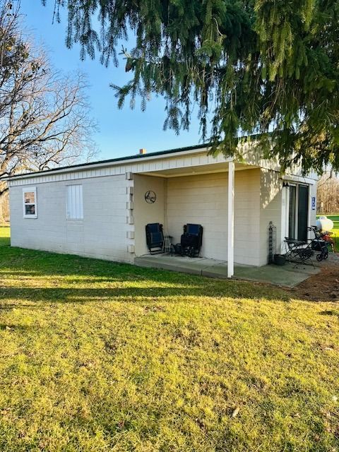 rear view of property featuring a yard and a patio