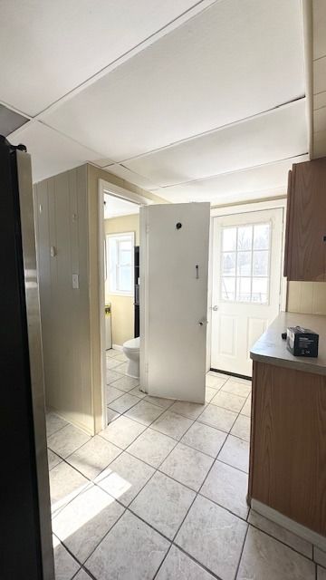 kitchen with light tile patterned flooring and stainless steel fridge