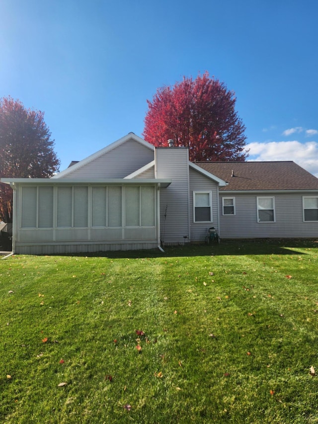 rear view of property with a yard