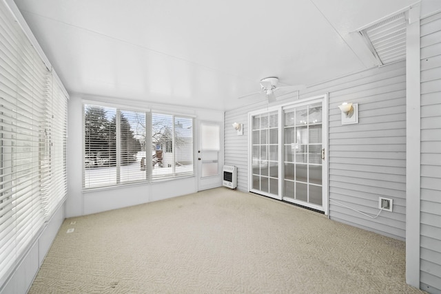 unfurnished sunroom with ceiling fan and heating unit