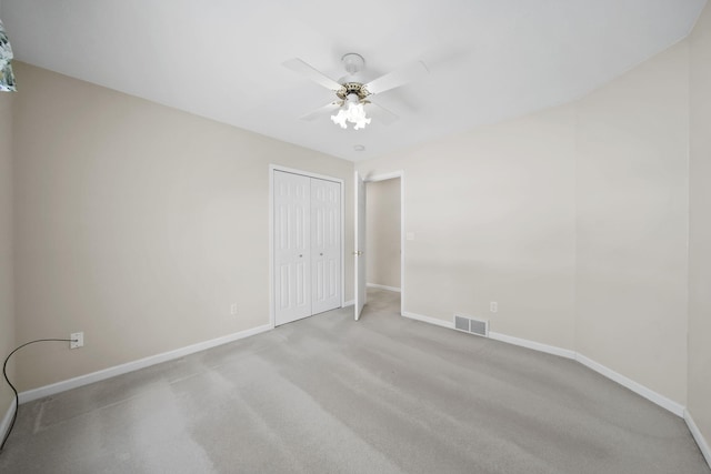 spare room featuring ceiling fan and light carpet