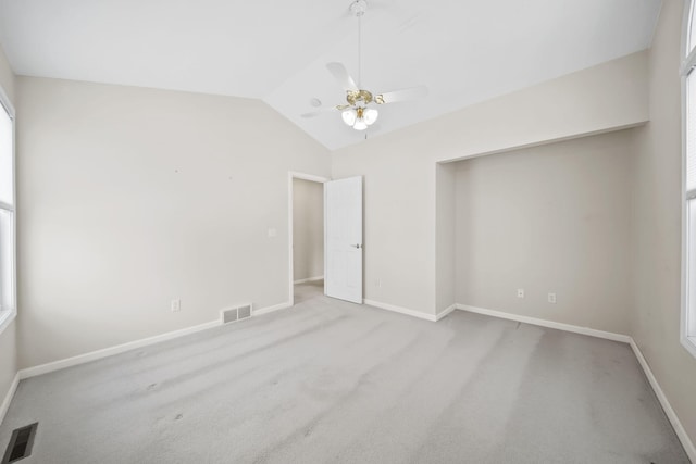 carpeted empty room with ceiling fan and lofted ceiling