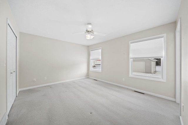 unfurnished room with ceiling fan and light carpet