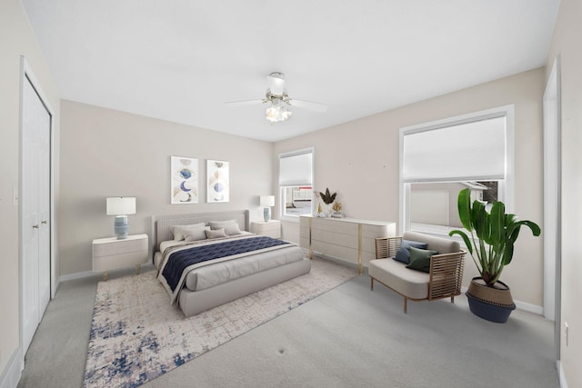 bedroom with light carpet, ceiling fan, and a closet