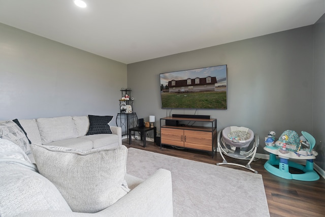 living room with dark wood-type flooring and baseboards