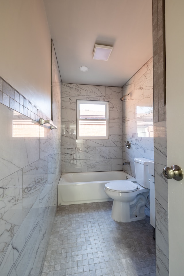 bathroom featuring tiled shower / bath combo and toilet