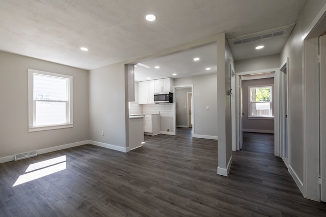 unfurnished living room with dark wood-type flooring