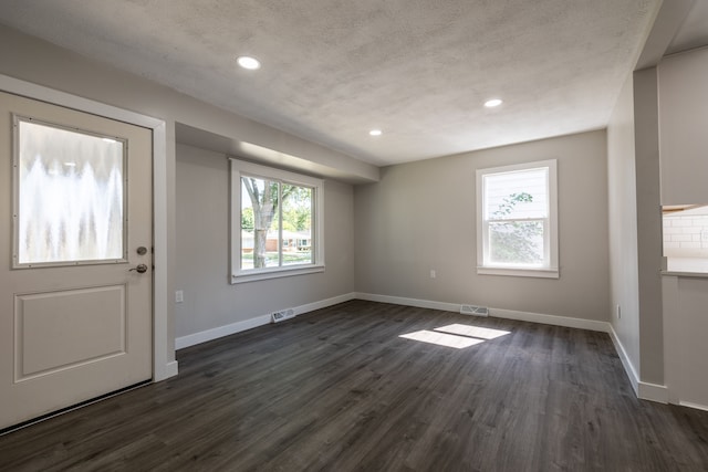 entryway with dark wood-type flooring and a textured ceiling