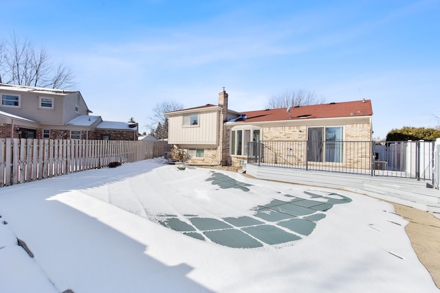 view of snow covered rear of property