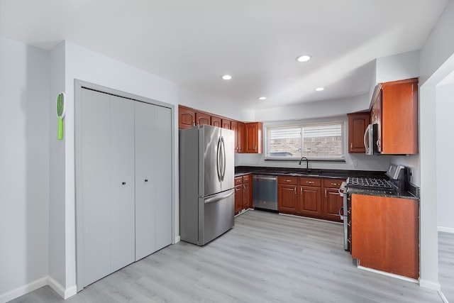 kitchen featuring stainless steel appliances, sink, and light wood-type flooring