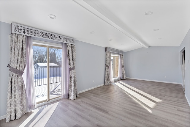 unfurnished room with light hardwood / wood-style flooring and vaulted ceiling with beams