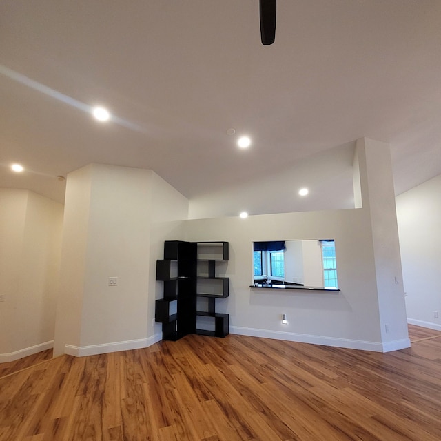 unfurnished living room with wood-type flooring and vaulted ceiling