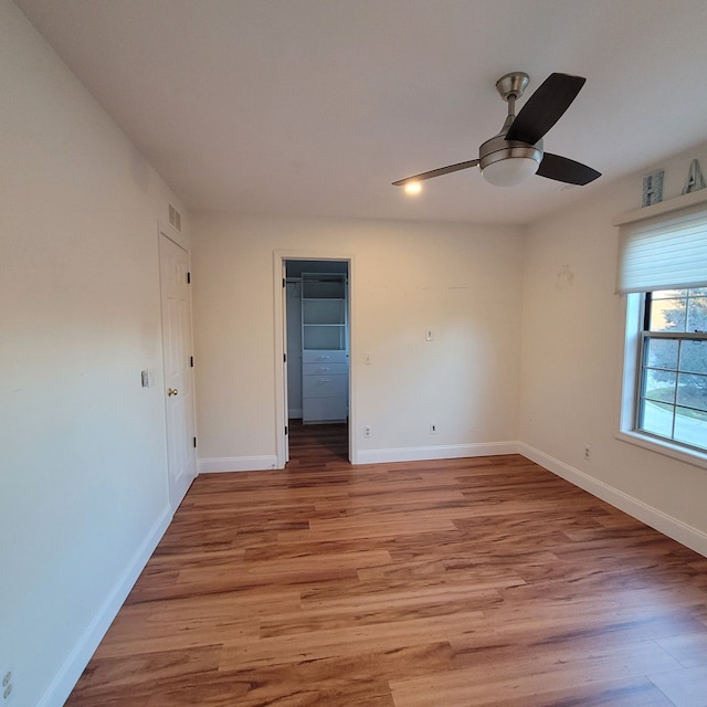 empty room with ceiling fan and light wood-type flooring