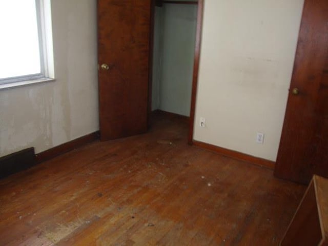 unfurnished bedroom featuring dark hardwood / wood-style floors and a closet