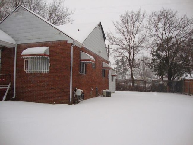 view of snow covered exterior with central AC