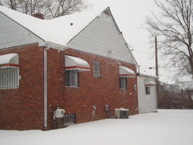 view of snowy exterior with central AC unit