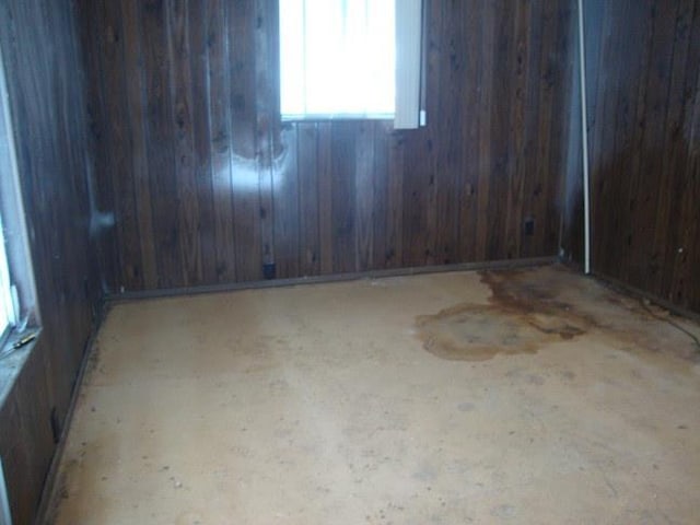 unfurnished room with wood walls