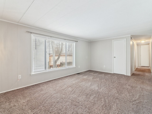 carpeted spare room with crown molding