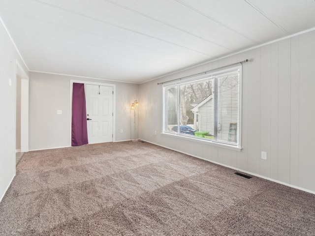 carpeted empty room featuring crown molding