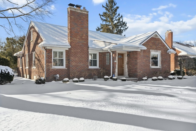 view of front of home featuring brick siding and a chimney