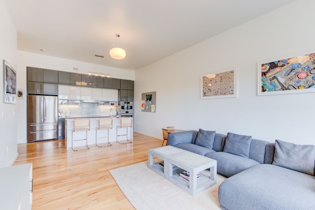 living room featuring sink and light hardwood / wood-style floors