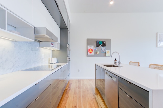 kitchen featuring wall chimney exhaust hood, sink, black electric cooktop, dishwasher, and backsplash