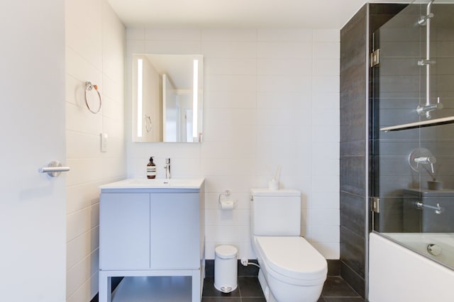 full bathroom with vanity, tile patterned floors, shower / bath combination with glass door, and toilet