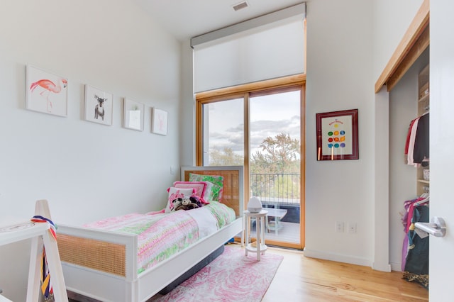 bedroom featuring access to exterior and light hardwood / wood-style flooring