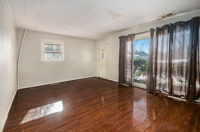 unfurnished room with dark wood-type flooring and a wealth of natural light