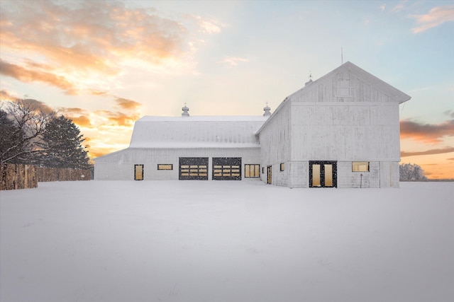 snow covered property with an outdoor structure