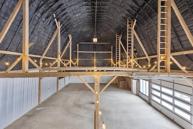 interior space with vaulted ceiling and concrete flooring