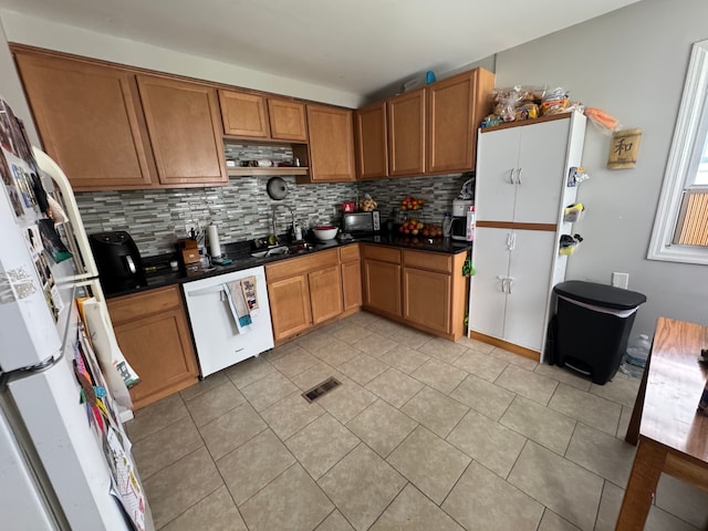 kitchen with tasteful backsplash, dishwasher, sink, and light tile patterned flooring