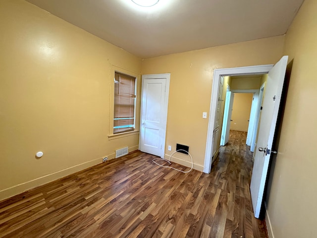 unfurnished bedroom with dark wood-type flooring