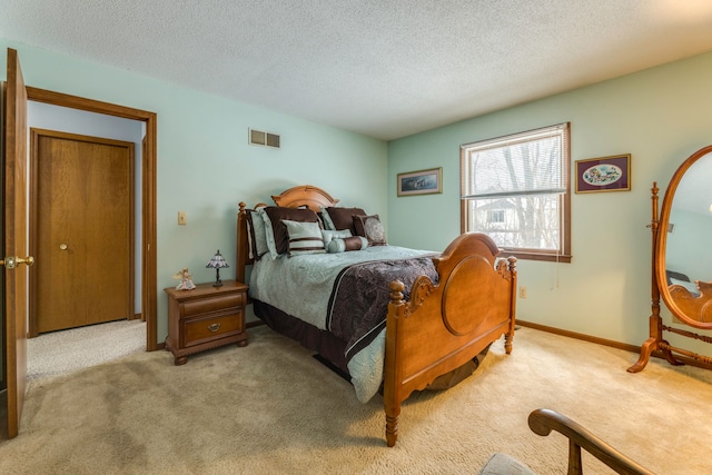 bedroom with light colored carpet and a textured ceiling